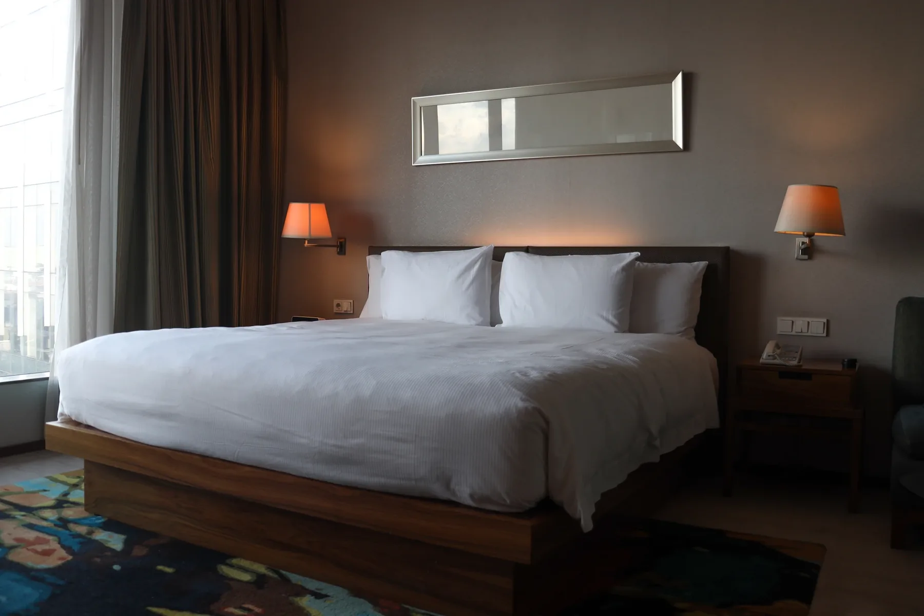 A hotel-style double bed freshly made up with white linen, ready for guest arrival