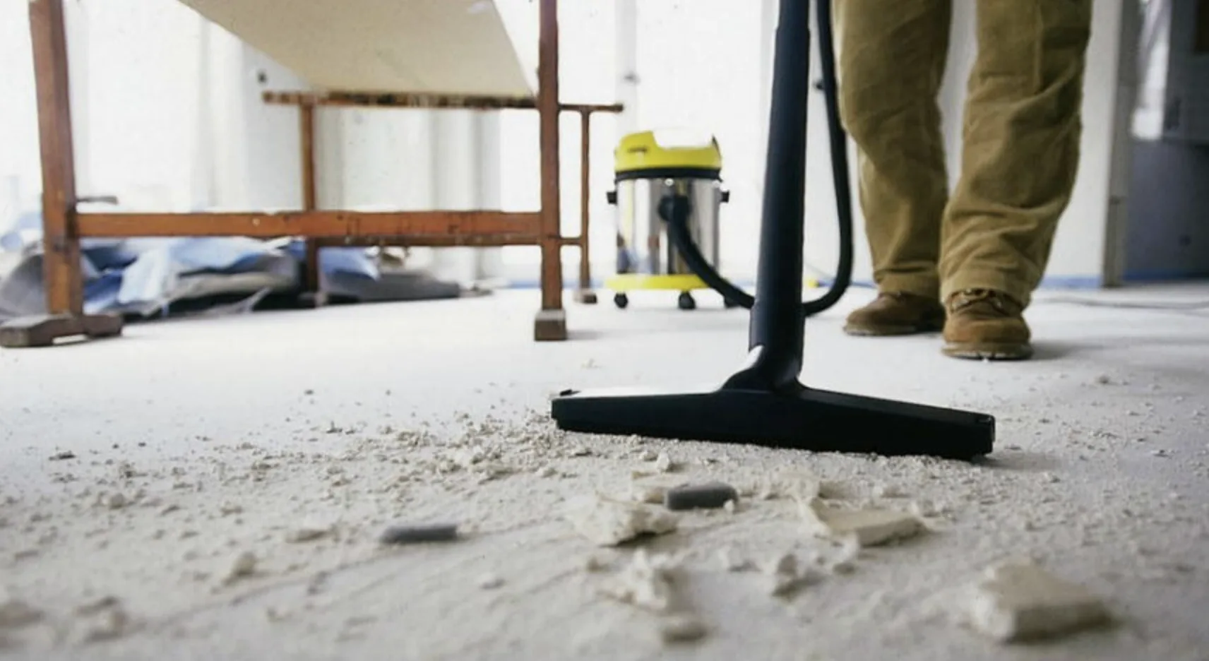 A vacuum clearing plaster dust and debris from a floor after building work